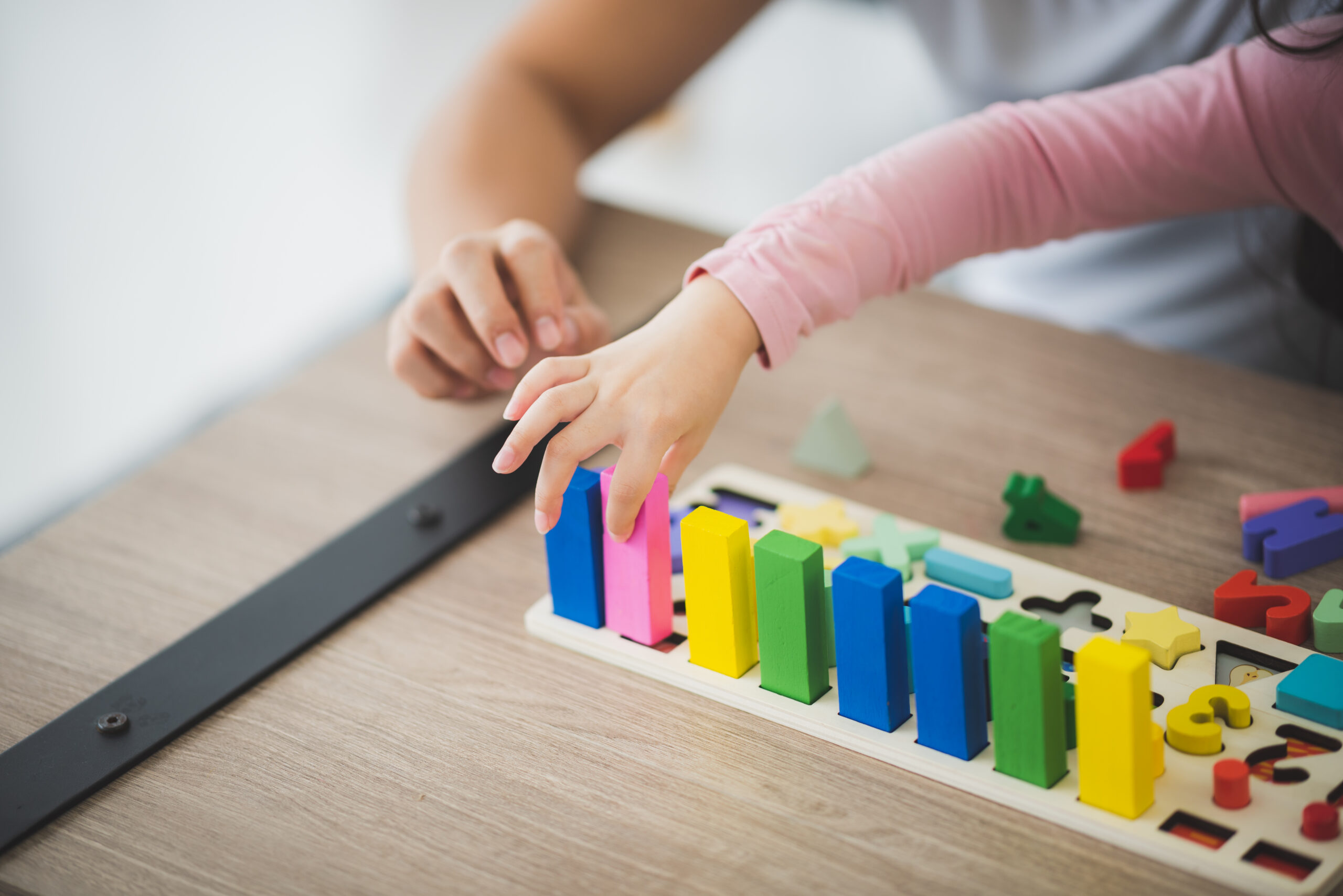 parent and girl playing Lego toddler brick blocks at home to improve life skill and education of preschool. Family leisure activity and communication